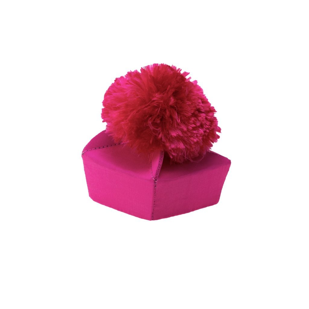 Souvenir della Berrettina: Un cappello rosa acceso con un grande e soffice pon-pon rosso in cima, su sfondo bianco.