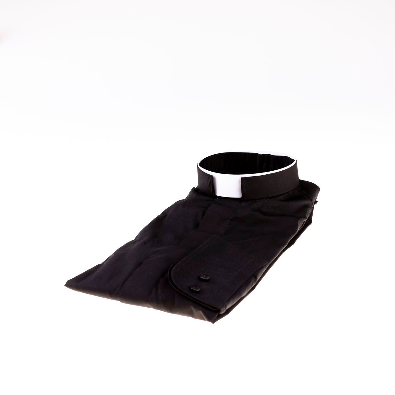 Una Camicia con Collo Romano, nera e ordinatamente piegata con un colletto clericale bianco, è esposta su uno sfondo bianco.