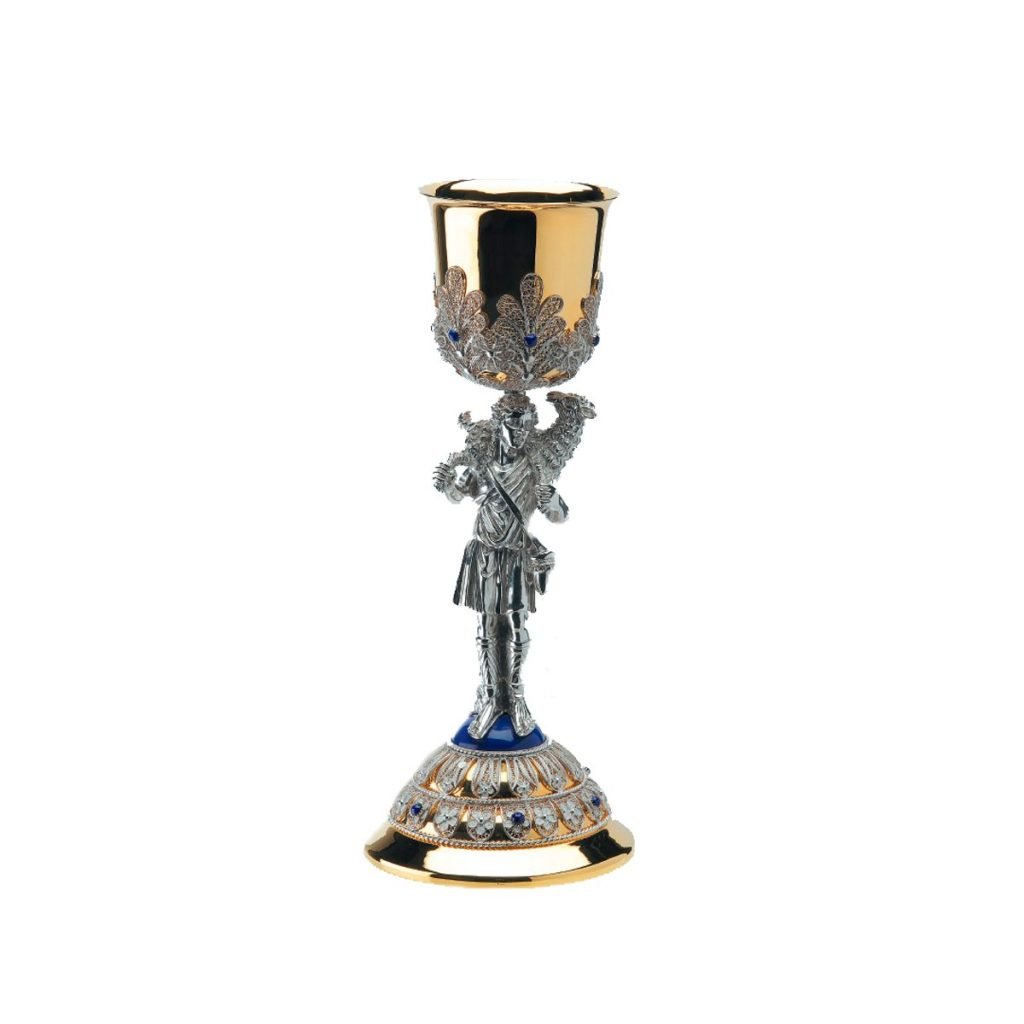 Il Calice Buon Pastore è un calice in oro e argento con una dettagliata figura di cavaliere sul gambo, ornata da gioielli e disegni intricati.