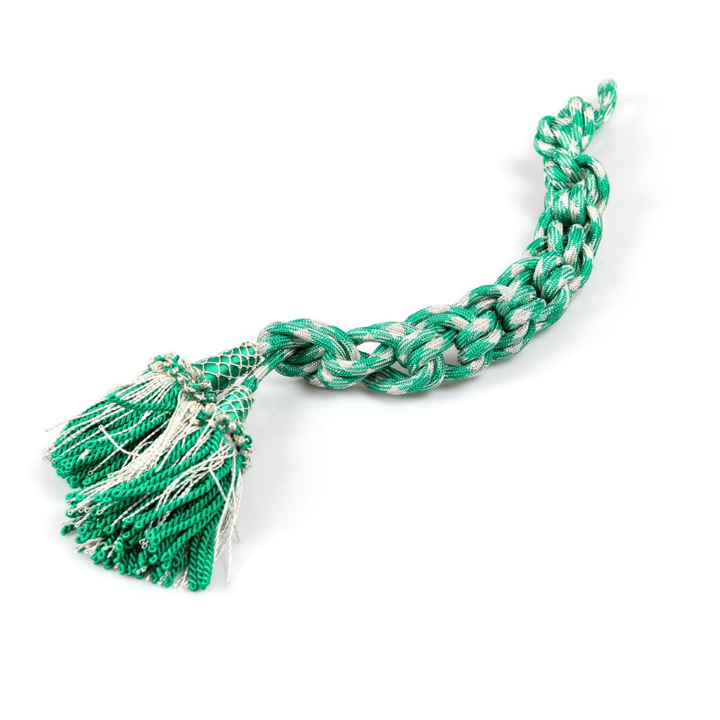 Cingolo Fiocco Romano Misto Oro o Argento giocattolo in corda con estremità sfrangiate, caratterizzato da un disegno intrecciato verde e bianco, su sfondo bianco.