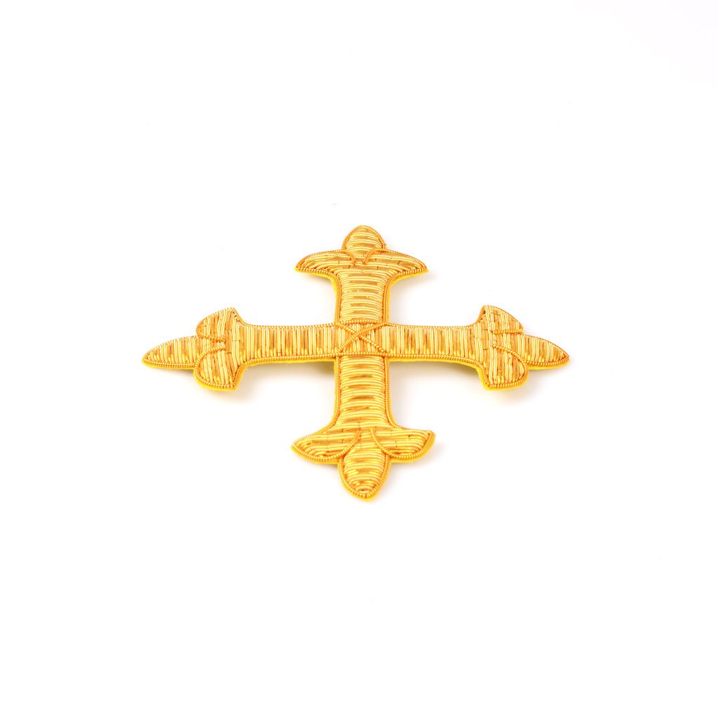 Applicazione Croce Fiorentina in Canutiglia: croce ornamentale in oro con disegno strutturato, ispirata all'eleganza della Sartoria Gammarelli, raffigurata su sfondo bianco.