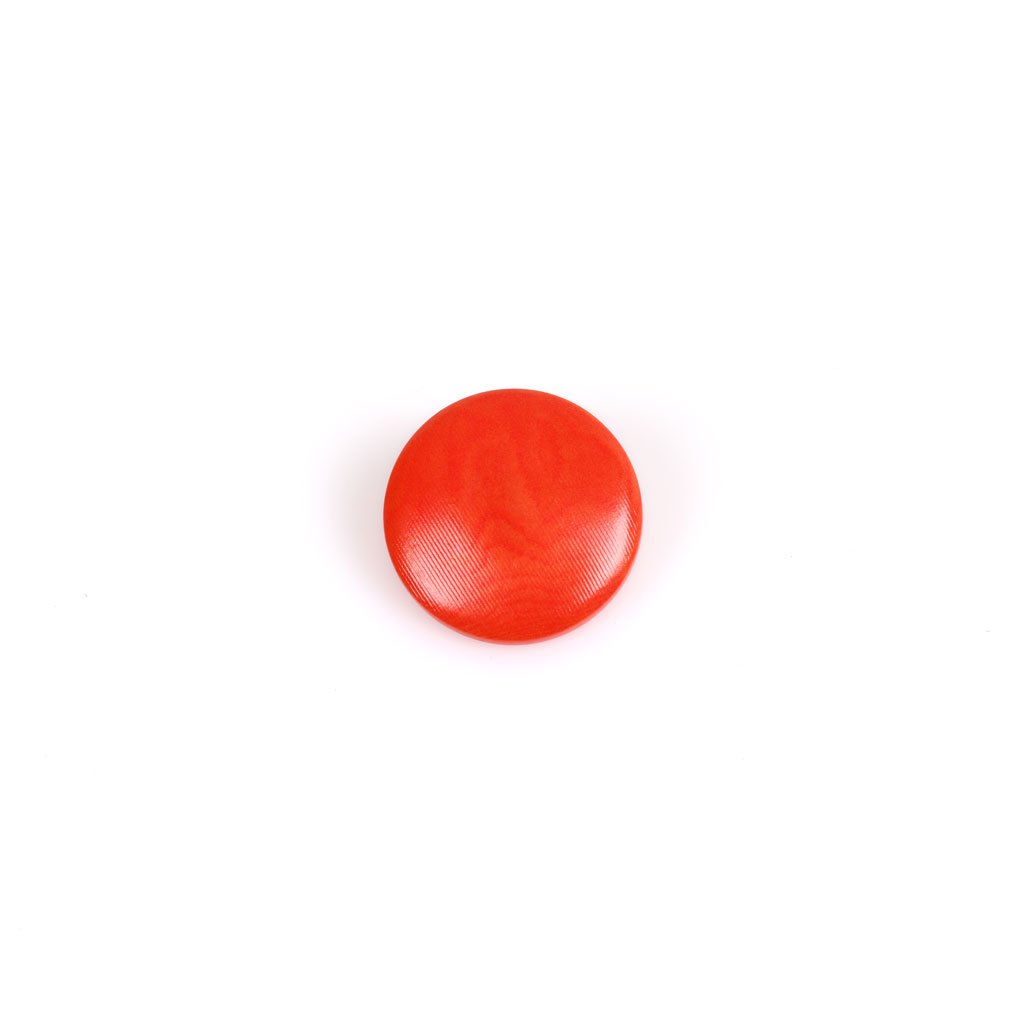 Un Bottone Corozo per Sottana visualizzato come un singolo bottone rotondo rosso su sfondo bianco.