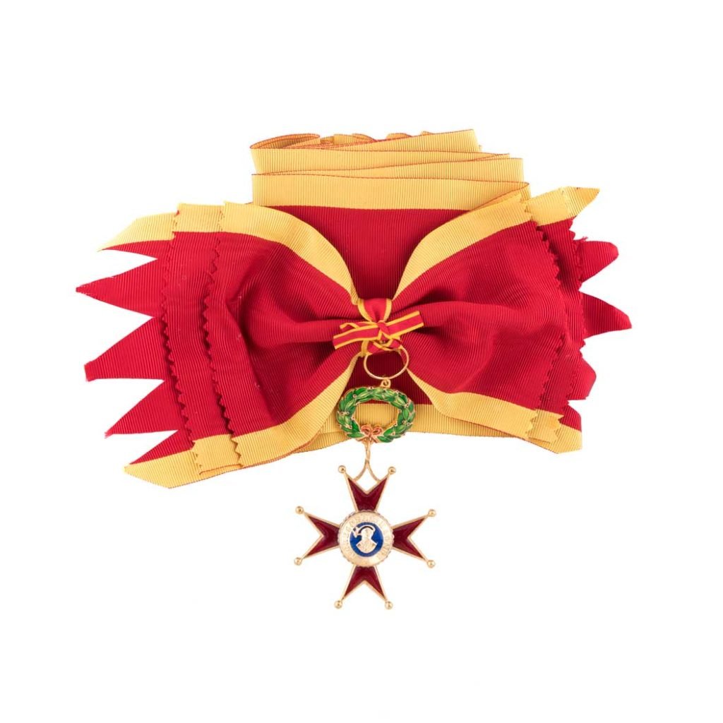 La Decorazione per Cavaliere Gran Croce Ordine San Gregorio Magno presenta una fascia con nastro rosso e oro e una medaglia a forma di stella in oro e smalto.