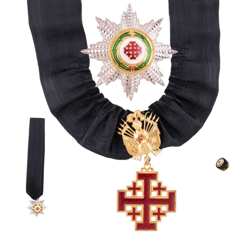 Decorazione per Grand'Ufficiale Ordine Santo Sepolcro: Medaglia con croce di Gerusalemme con nastro, fascia nera, distintivo a stella e piccola coccarda su sfondo bianco: un'elegante insegna ufficiale.