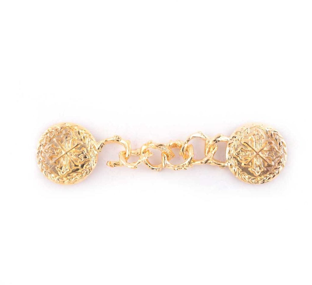 Ganci per Piviale Croce Costantiniana: chiusura decorativa in oro ispirata alla sartoria Gammarelli, presenta due estremità tonde collegate da una catena, visualizzate su sfondo bianco.
