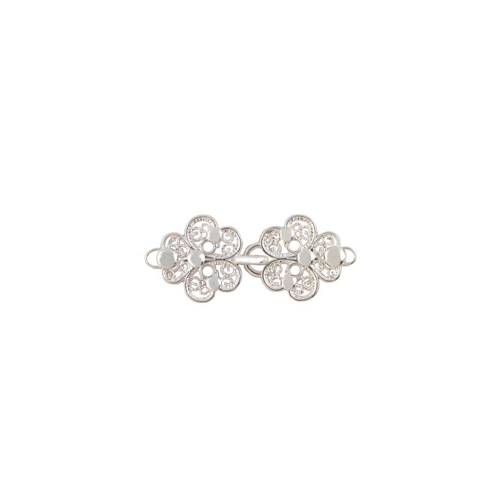 Il Ganci Modello Trifoglio è una raffinata spilla in argento che presenta due forme floreali con accenti di gemme chiare, ispirate all'eleganza della Sartoria Gammarelli e rifinite con chiusure ganci sicure.
