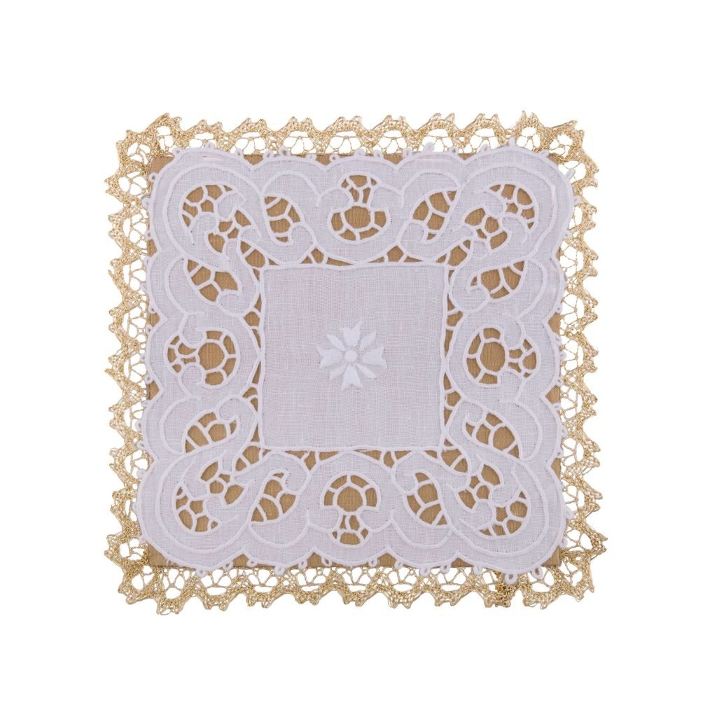 Palla con Merletto: un centrino quadrato di pizzo bianco con bordi dorati e intricati motivi di ritagli, su uno sfondo bianco.