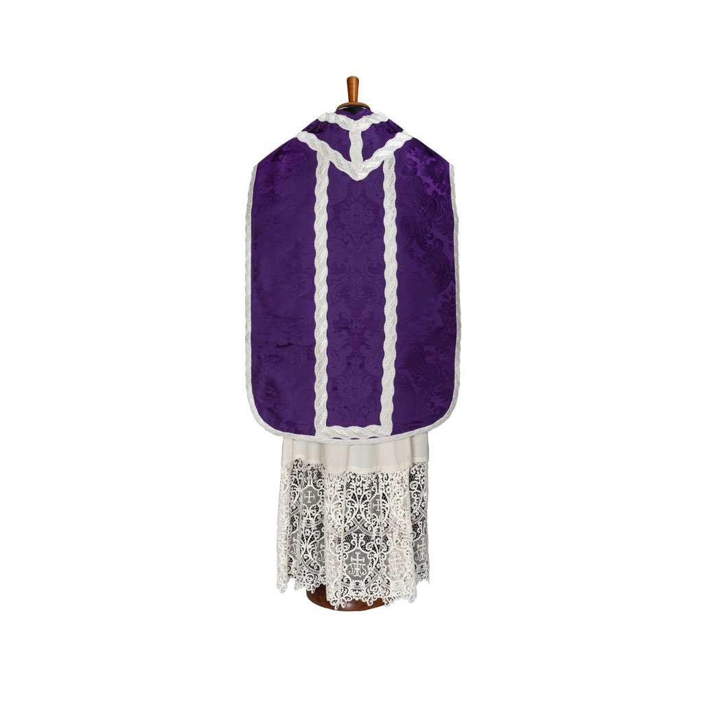 La Pianeta Romana in Damasco Nocca, un paramento viola con finiture bianche di Gammarelli Sartoria, è esposta su un cavalletto sopra un abito di pizzo bianco.