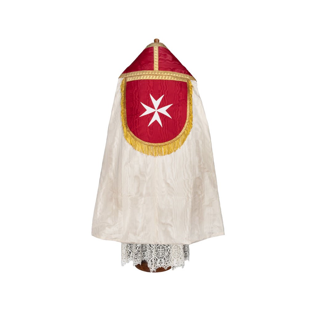 Il Piviale Romano Modello S.M.O.M. è un mantello da cerimonia rosso e bianco con finiture dorate, caratterizzato da una croce bianca a otto punte su un pannello rosso a forma di scudo.