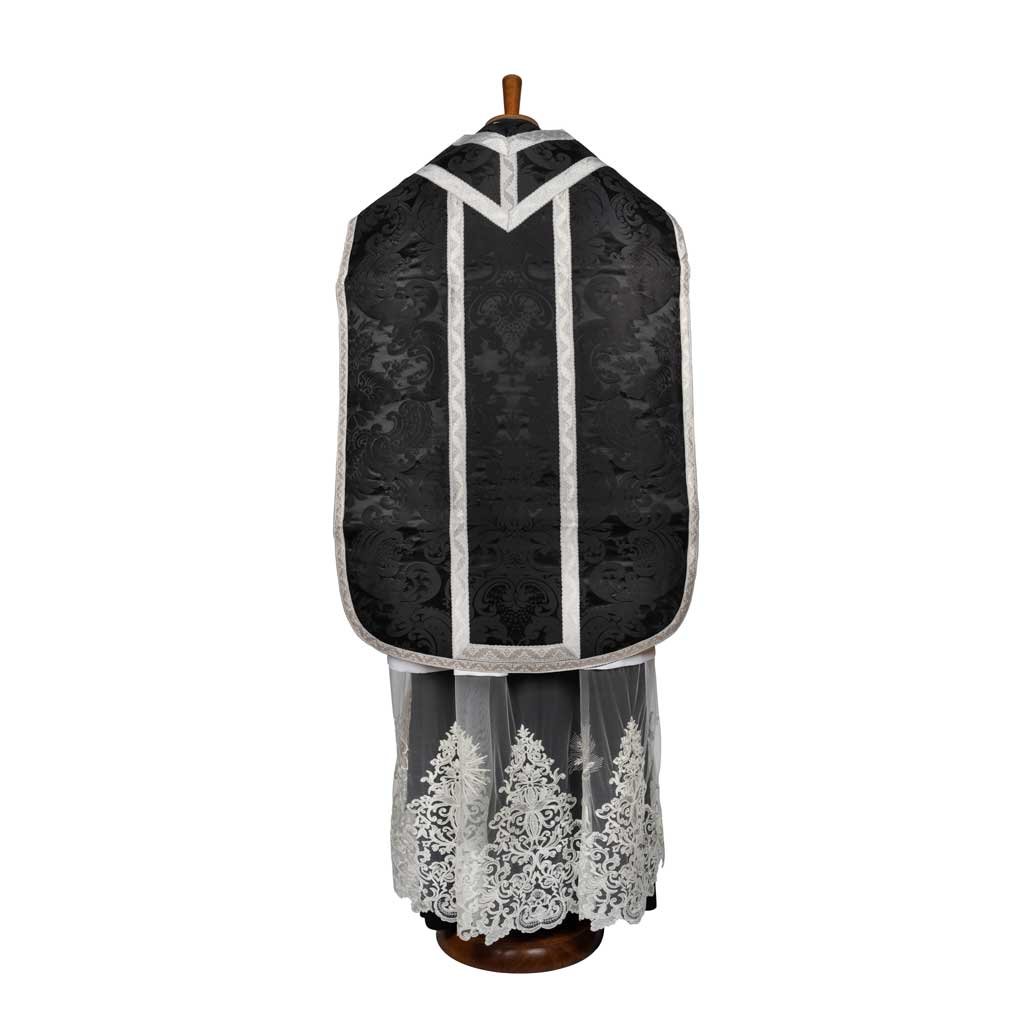 Il Pianeta Romana Damasco Nocca, un paramento ricamato in bianco e nero della Gammarelli Sartoria, è mostrato su un manichino dal retro.