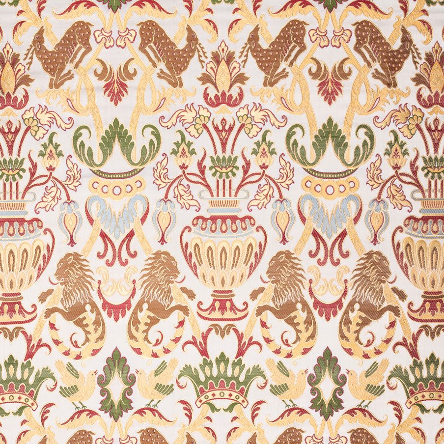 Lampasso Coronation presenta un motivo floreale e leonino ornato in oro, verde e rosso su sfondo bianco, che evoca lo stile degli arazzi vintage.