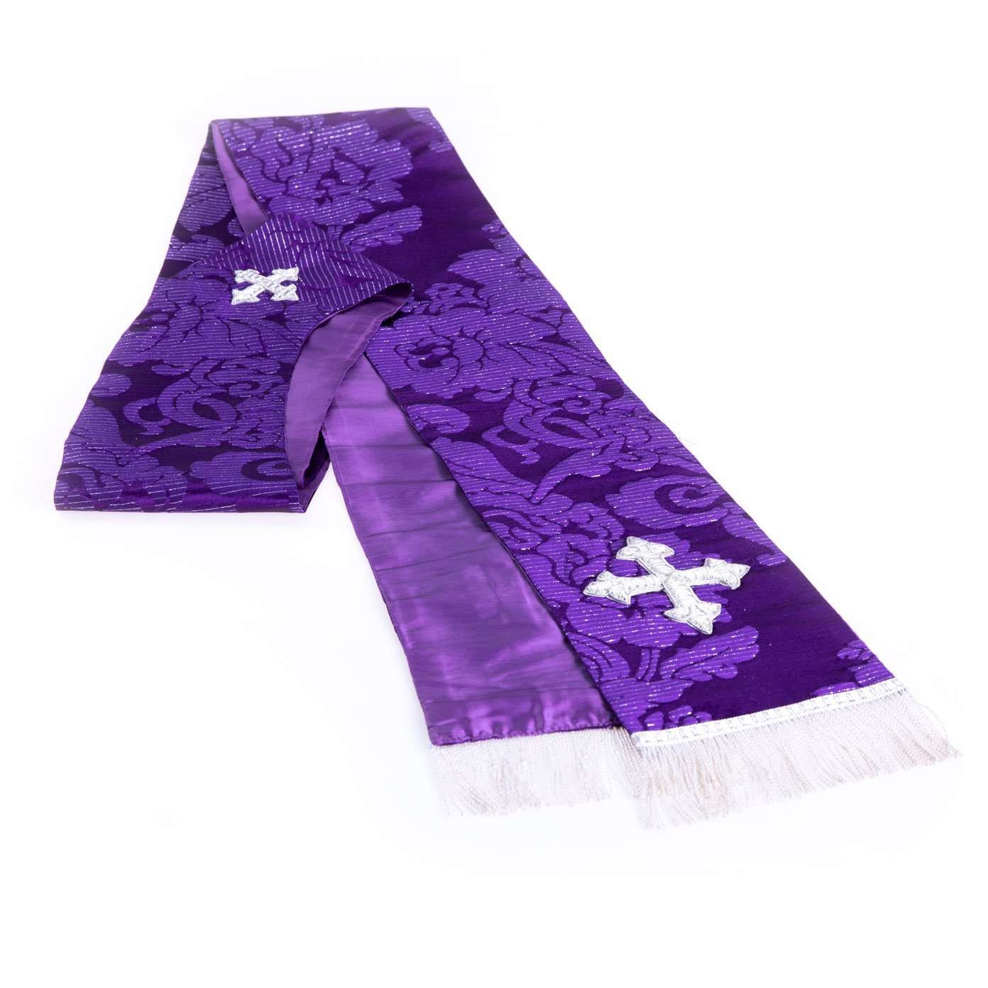 La Stola Gotica in Damasco Laminato è una stola clericale viola con frangia bianca e croci d'argento ricamate su ciascuna estremità, su sfondo bianco.