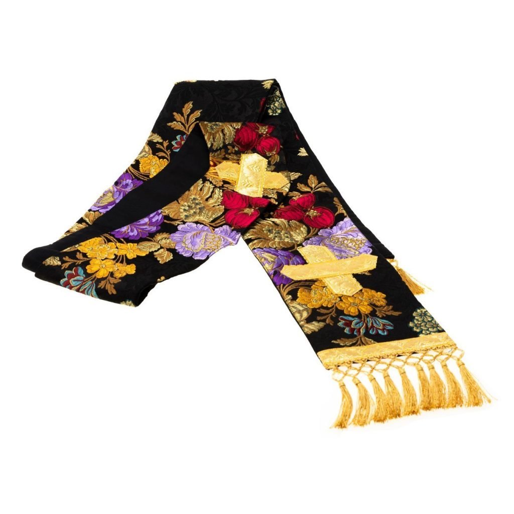 La Stola Gotica Broccato Savoia è una stola nera con ricami floreali in oro, rosso e viola e frange dorate alle estremità.